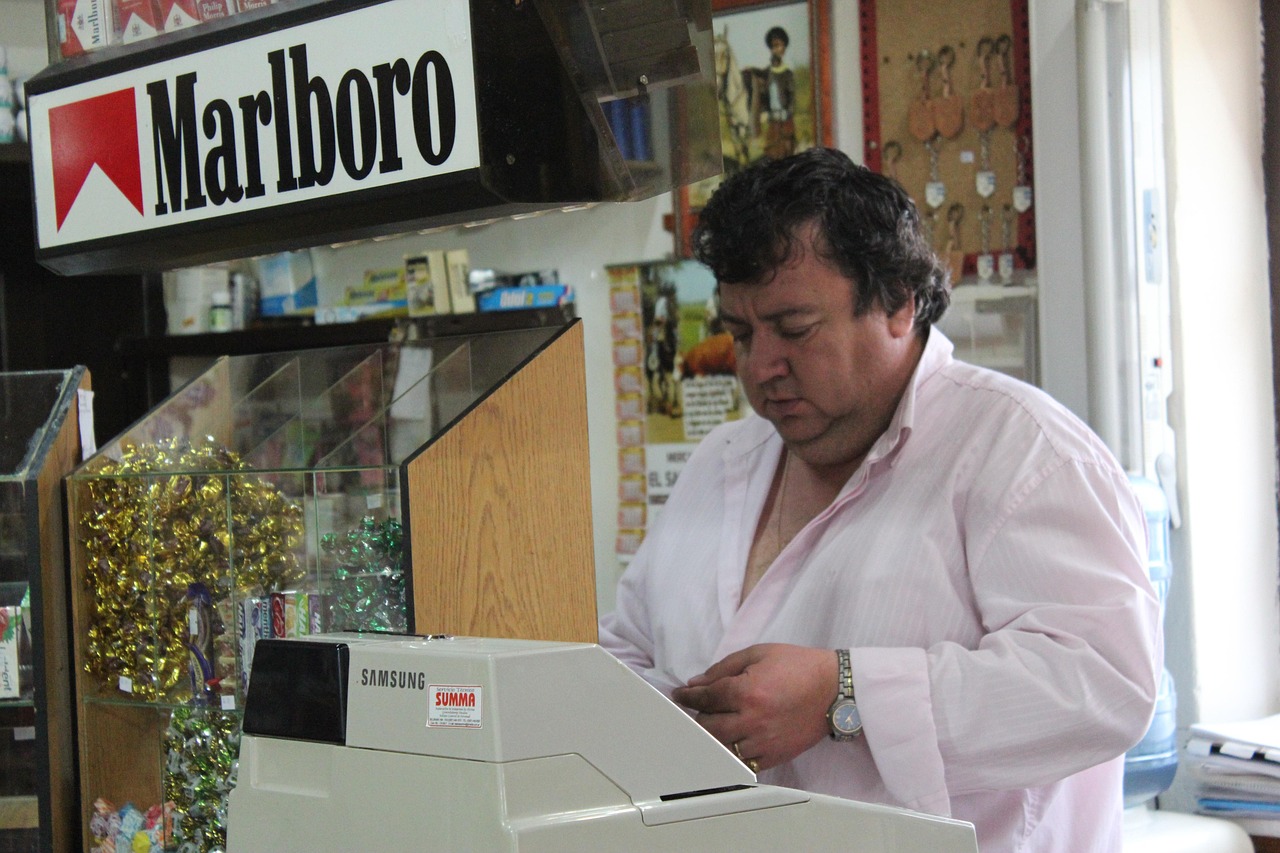 Immagine di un tabaccaio che mostra gratta e vinci con un sorriso, circondato da biglietti vincenti.