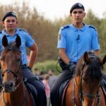 Vigile urbano in uniforme mentre controlla il traffico in una strada cittadina.